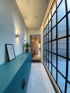 特罗佩阿NoOne Tropea Guesthouse的走廊设有蓝色柜台和大窗户