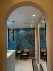 特罗佩阿NoOne Tropea Guesthouse的带有蓝墙的走廊,带有树壁画