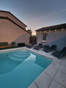 克莱蒙费朗Maison individuelle avec sa piscine privée的一座游泳池,旁边设有椅子