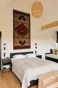 格利查尔Osada Matygówka的卧室配有一张床,墙上挂着地毯