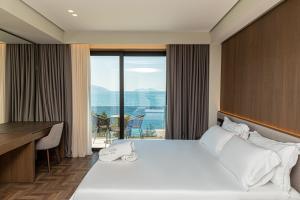 伏罗拉Mazarine Hotel, Vlorë, Albania的酒店客房设有一张床和一张书桌,享有美景。