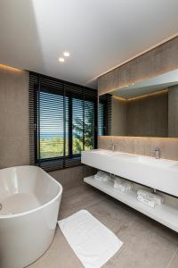 伏罗拉Mazarine Hotel, Vlorë, Albania的一间带大浴缸和大镜子的浴室