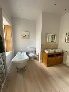 AllantonPurves Cottage的一间带两个盥洗盆、浴缸和卫生间的浴室