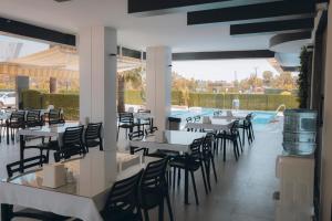 锡利夫凯PALMİLA BUTİK OTEL的一间带桌椅的餐厅和一个游泳池