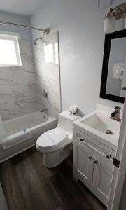 洛克威海滩银沙汽车旅馆的白色的浴室设有卫生间和水槽。