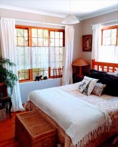 开普敦Lavender Cottage的一间卧室设有一张大床和窗户。