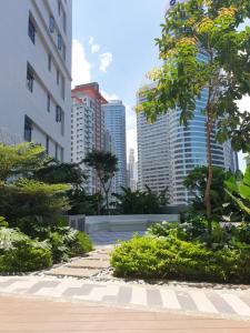 马尼拉Heart of Makati, Fully furnished condo, cbd central location的一座位于城市中心,拥有高楼的花园