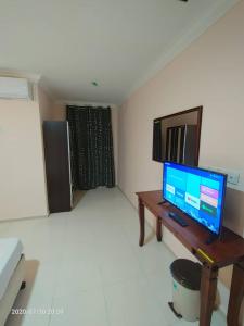 龙运TAMIM SUITE GROUP HOTEL Dungun的客厅配有电视和带电脑的书桌