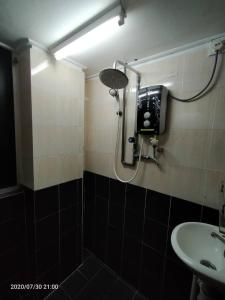 龙运TAMIM SUITE GROUP HOTEL Dungun的带淋浴、水槽和灯的浴室
