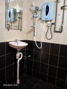 龙运TAMIM SUITE GROUP HOTEL Dungun的带淋浴、水槽和镜子的浴室