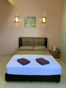 龙运TAMIM SUITE GROUP HOTEL Dungun的房间里的一张床位,上面有两条毛巾
