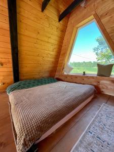 ChereshenkaBlackcherry_Ukraine的小木屋内的一张床位,设有窗户