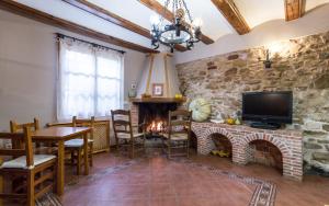 GalveCasa Rural La Yedra的客厅设有石墙和壁炉。