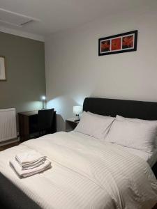 博尔顿Comfortably furnished 2 bedroom home in Bolton的一间卧室配有一张床,上面有两条毛巾