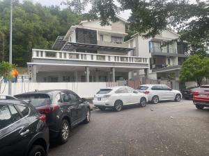 峇六拜20PAX 4BR Villa with Kids Swimming Pool, KTV, Pool Table n BBQ near SPICE Arena Penang的停在大楼前的一组汽车