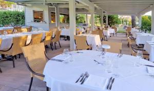 马里纳迪马萨埃尔莎别墅酒店的餐厅配有桌椅和白色的桌布