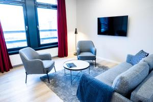 森讷堡Hotel Sønderborg Kaserne的客厅配有沙发、两把椅子和一张桌子