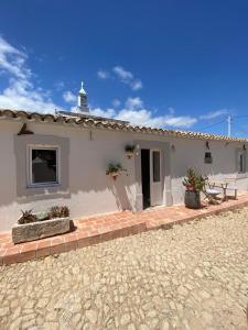 法鲁Vila Lobo Algarve的白色的房子,配有桌子和庭院