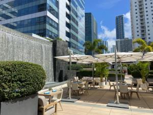 迈阿密Four Seasons Hotel Miami - Luxury Private Residences的一个带桌椅和遮阳伞的庭院