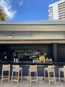 迈阿密Four Seasons Hotel Miami - Luxury Private Residences的酒吧设有四把椅子和柜台
