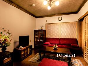 京都Kyoisuke的客厅配有红色沙发和电视
