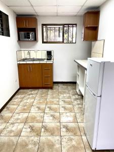 圣何塞Hermoso apartamento en la capital de Costa Rica的厨房配有白色冰箱,铺有瓷砖地板。