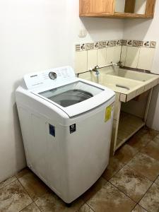 圣何塞Hermoso apartamento en la capital de Costa Rica的洗涤槽旁厨房里的洗衣机