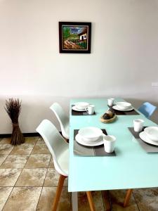 圣何塞Hermoso apartamento en la capital de Costa Rica的一张带白色板子和椅子的蓝色餐桌