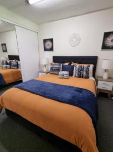 金皮Nomads Rest的一间卧室配有一张大床,铺有蓝色和橙色床单。