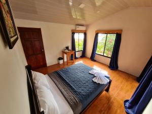 德雷克Osa Corcovado Lodge的一间卧室设有一张床和两个窗户。