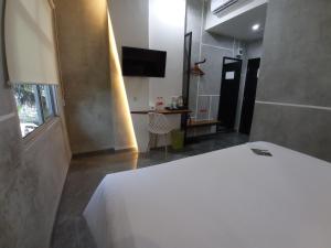 Talang KelapaRid's Hotel Palembang的卧室配有白色的床和电视。