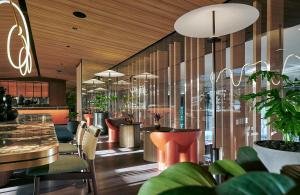 吉隆坡吉隆坡宾乐雅臻选酒店的一间设有桌椅和盆栽的餐厅