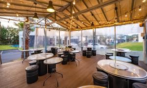 济州市索朗泳池别墅的餐厅设有桌子和凳子,位于带窗户的房间内