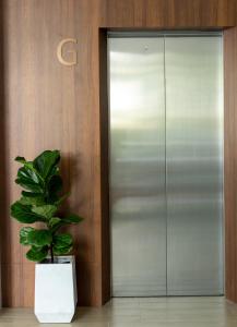 拉瓦斯All Are Welcome Lawas Boutique Hotel的坐在电梯前的盆栽植物