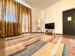 阿特劳萨莱巴图旅馆的客厅设有大窗户和平面电视。