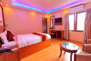 加德满都Everland Kathmandu Hotel的一间卧室配有一张床、一张桌子和一张沙发