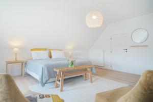 Frasnes-lez-AnvaingA Coque'Line的白色卧室配有床和桌子