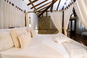 卡尔达斯·德·雷斯托雷多里奥酒店的一张带白色床单和枕头的床