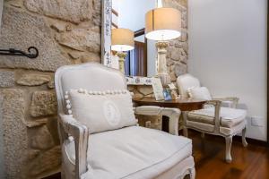 卡尔达斯·德·雷斯托雷多里奥酒店的一间设有白色椅子和一张桌子的房间