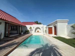 乌鲁瓦图Moana Villa & Suites Bingin的房屋前的游泳池