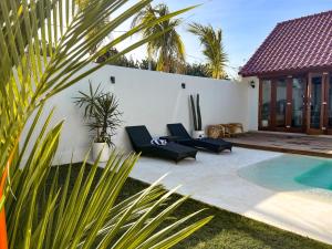 乌鲁瓦图Moana Villa & Suites Bingin的一个带游泳池和别墅的后院