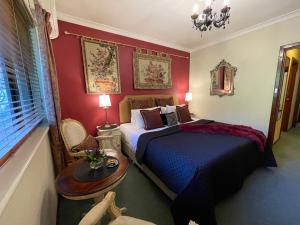 玛格丽特河紫檀木宾馆的一间卧室配有一张床、一张桌子和一个窗户。