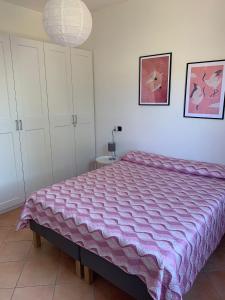 博萨A Casa di Nonna的一间卧室配有一张大床和紫色毯子