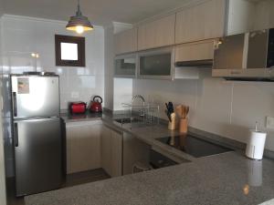 科金博玛拉塞雷纳花园公寓的厨房配有不锈钢冰箱和橱柜