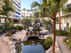 坎德拉里亚加泰罗尼亚蓬塔德雷酒店的庭院里的喷泉,庭院里设有长凳和池塘