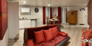 吉尼亚克Gignac - Superbe cocon indépendant avec balnéo et jardin的一间带红色沙发的客厅和一间厨房