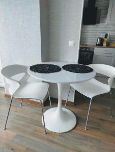 基维厄利Kotkapesa Apartment的厨房里配有白色的桌椅