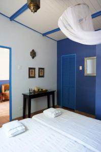 克拉伦代克加勒比休闲公寓的一间蓝色的卧室,配有白色的床和一张桌子