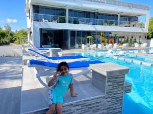 瓦塔穆Bingo House Watamu, A Modern 5-Bedroom Villa with Pool, A Kids Heaven的站在游泳池旁的小女孩