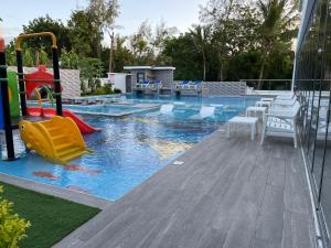 瓦塔穆Bingo House Watamu, A Modern 5-Bedroom Villa with Pool, A Kids Heaven的一个带滑梯和游乐场的游泳池